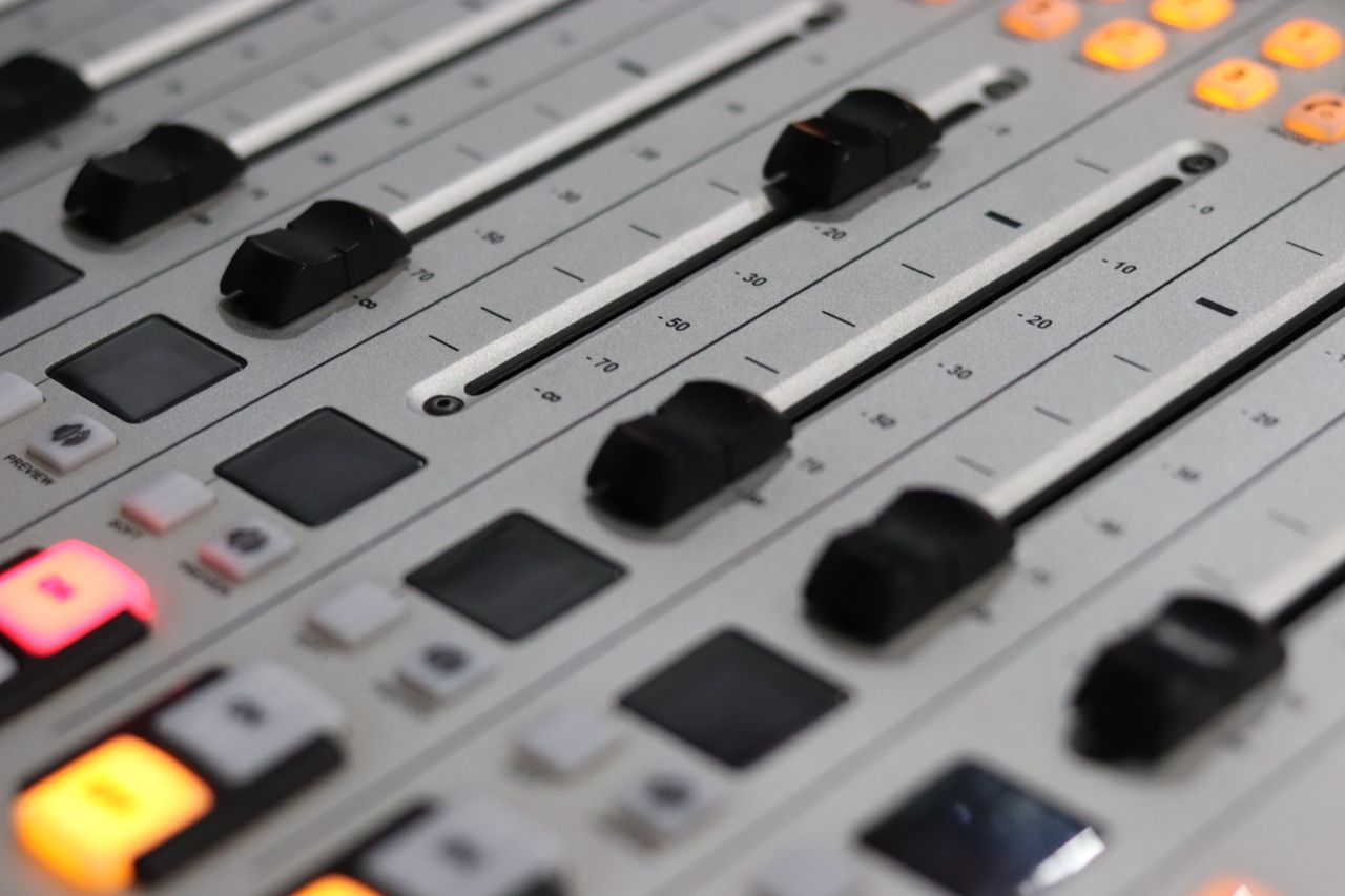 Crafting Captivating Headlines: Your awesome post title goes here Close-up view of a professional audio mixer with sliders and control knobs, ideal for sound production.