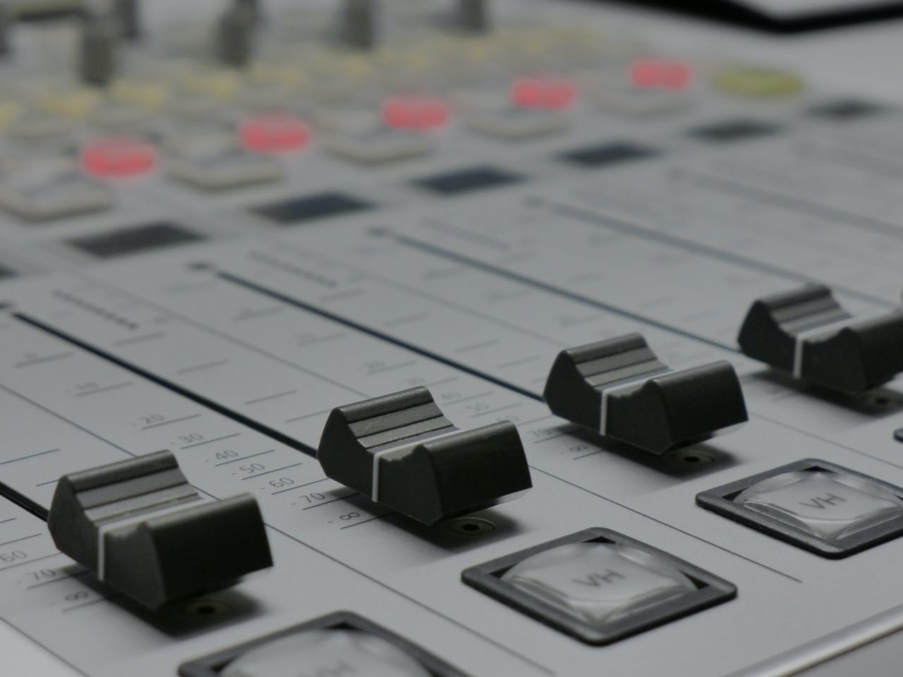 The Art of Drawing Readers In: Your attractive post title goes here Detailed view of audio mixer sliders in a recording studio setting.